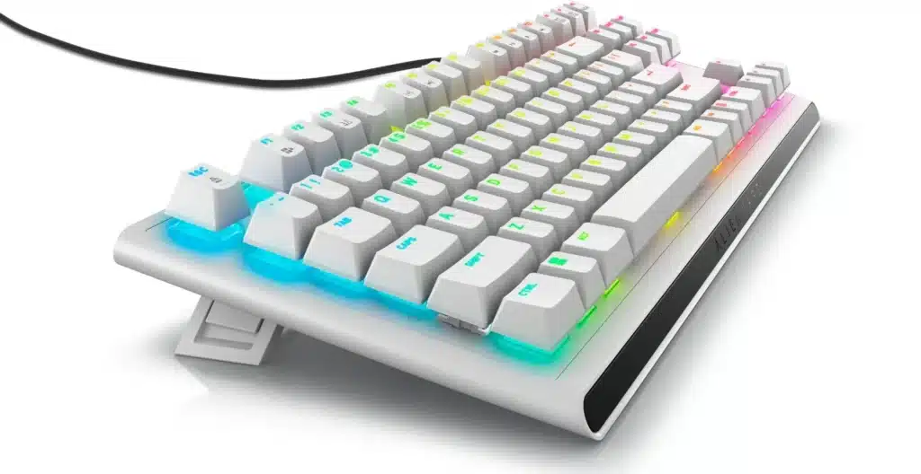 Foto promocional del teclado para juegos Alienware Tenkeyless tomada a la izquierda.  Tiene iluminación RGB debajo de las teclas mecánicas.  Fondo blanco.